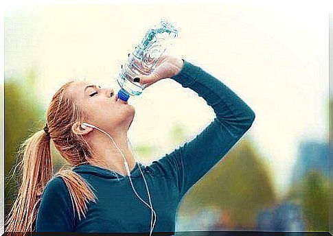 Woman drinking a sports drink while jogging