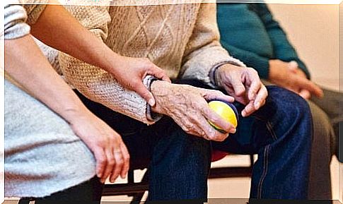 Woman holding the hand of a patient with Parkinson's disease