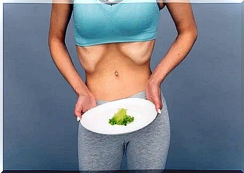 Woman holding a plate with a salad leaf